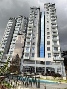 two tall buildings with a pool in front of them at Apartment in Kitusuri in Nairobi