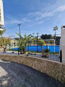 a fence in front of a swimming pool at La Petite Finca in Elche