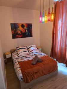 a bed in a bedroom with a painting on the wall at L'Escapade Chablisienne in Chablis