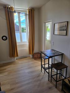 a room with a table and two chairs and a window at L'Escapade Chablisienne in Chablis