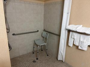 a shower with a chair in a bathroom at Magnason Hotel in West Liberty