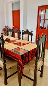 a dining room table with a red table cloth on it at La Casa Rustica in Puerto Chicama