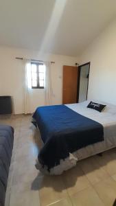 a bedroom with a large bed with a blue blanket at Departamento Olivia in Ushuaia