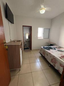 a bedroom with a bed and a dresser and a television at Pousada Nascer da Lua in São Thomé das Letras +14 photos