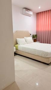 a bedroom with a bed and a red curtain at 3 Ls APARTAMENTO in Luanda