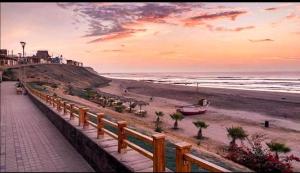 a boardwalk leading to a beach with a boat on it at La Casa Rustica in Puerto Chicama