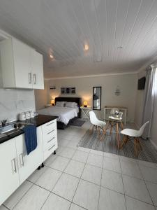 a kitchen and a bedroom with a bed and a table at The Ceed in Beacon Bay