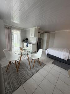 a bedroom with a bed and a table and chairs at The Ceed in Beacon Bay +18 photos