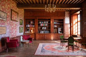 a room with chairs and a table and bookshelves at Le Logis d'Equilly in Équilly