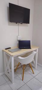 a desk with a laptop and a monitor and a chair at The Ceed in Beacon Bay