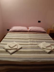 a bed with two pillows and napkins on it at Casa Marina in Omegna
