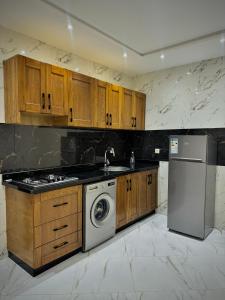 a kitchen with wooden cabinets and a washing machine at Résidence Maryam in Nador