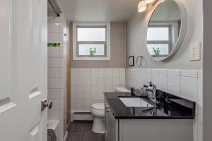a bathroom with a sink and a toilet and a mirror at 2 Mins from Airport 1 BDR with Large Backyard in Anchorage