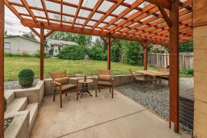 a patio with a wooden pergola with a table and chairs at 2 Mins from Airport 1 BDR with Large Backyard in Anchorage