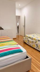 two beds in a room with wooden floors at 3 Ls APARTAMENTO in Luanda