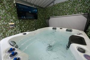 a bath tub with a tv and a tub at Castlecroft House with Hot Tub in Dungiven +42 photos