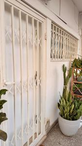 a white gate in a room with plants at 3 Ls APARTAMENTO in Luanda