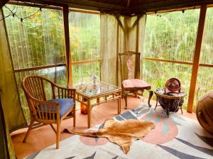 a room with a glass table and chairs in a room at Artsy Cabin on Organic Farm in Naalehu