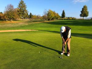 a man is playing golf on a golf course at Midi-Maisonette mit kleiner Dachterrasse und Blick ins Grüne in Petersberg