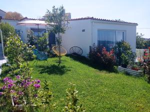 a garden with a table and chairs in the yard at LAR JARDÍN - Casas independientes con jardín y parking privado in Santiago de Compostela +53 photos
