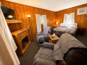 a hotel room with a bed and a tv at Cedars Motel in Saint Ignace +15 photos