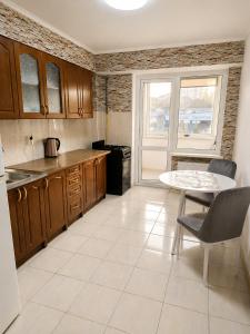 a kitchen with wooden cabinets and a table and a window at Apartament in Botanica in Chişinău