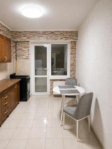 a kitchen with a table and chairs and a window at Apartament in Botanica in Chişinău