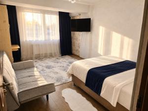 a bedroom with a bed and a chair and a window at Apartament in Botanica in Chişinău