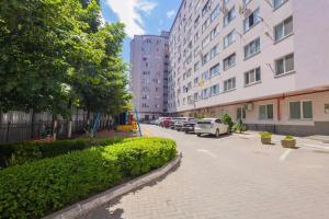 a city street with cars parked in front of buildings at Apartament in Botanica in Chişinău