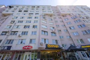 a large white building in front of a store at Apartament in Botanica in Chişinău +4 photos