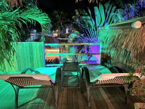 a deck with two tables and chairs and lights at Oasis Tropical in Paracuru