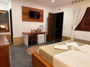 a bedroom with a bed and a desk and a television at Oasis Tropical in Paracuru +16 photos