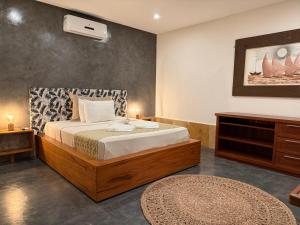a bedroom with a large bed with a dresser and a table at Oasis Tropical in Paracuru