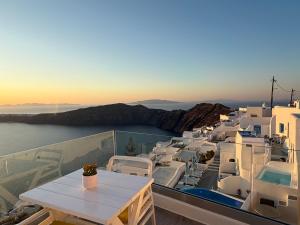 a balcony with a table and a view of the ocean at Esmi Suites Santorini in Imerovigli