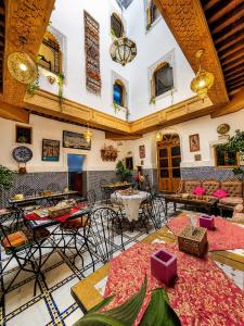 a large room with tables and chairs in a building at Riad Tafoukt Palace in Fez