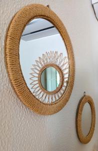 a rattan mirror with a rattan frame on a wall at Karpé diem in Saint-François +18 photos