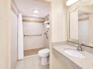 a bathroom with a toilet and a sink at Travelodge by Wyndham Barstow in Barstow