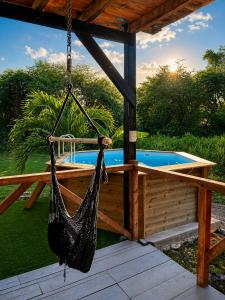 a hammock hanging from a pergola next to a pool at evasion guadeloupe in Malgré Tout