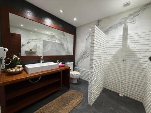 a bathroom with a white sink and a white brick wall at Pousada Oasis Paracuru in Paracuru