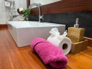 a pink towel sitting on the floor next to a sink at Pousada Oasis Paracuru in Paracuru