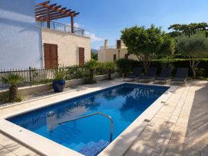 a swimming pool in front of a house at Villa Igalo Splitska - Private Pool & Sea View in Splitska