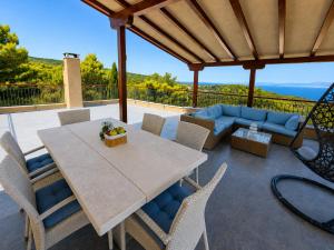 a patio with a table and chairs and a couch at Villa Igalo Splitska - Private Pool & Sea View in Splitska