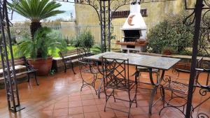 un patio con tavolo, sedie e griglia di Casa Vacanza Villa Morana a Baronissi