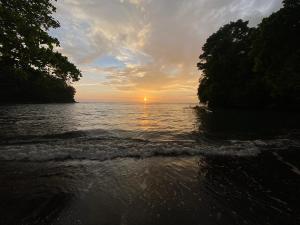 a sunset over the water with the sun setting at Ghia Boutique Homestay in Batuangus