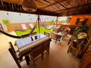 a room with a table and chairs and a hammock at Departmento Grande in Puerto Chicama