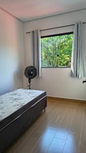 a bedroom with a bed and a large window at Sítio Belo Vale in Cataguases