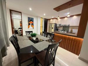 a dining room and kitchen with a table and chairs at Departmento Grande in Puerto Chicama
