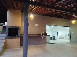 a kitchen with a counter and a large glass door at Sítio Belo Vale in Cataguases +4 photos