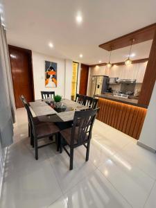 a dining room with a table and chairs and a kitchen at Departmento Grande in Puerto Chicama +29 photos