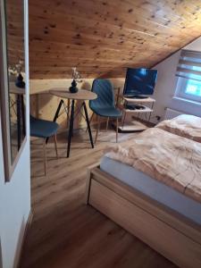 a bedroom with a bed and a table and chairs at Penzion Oáza Hřensko in Hřensko